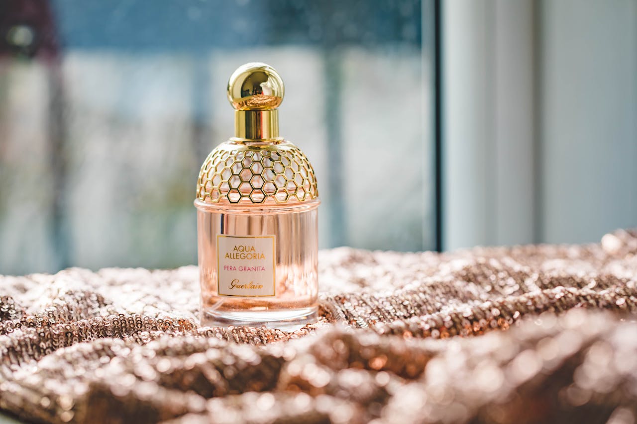 mobile-02 Elegant Guerlain perfume bottle on a textured fabric with natural lighting, exuding luxury and fragrance.