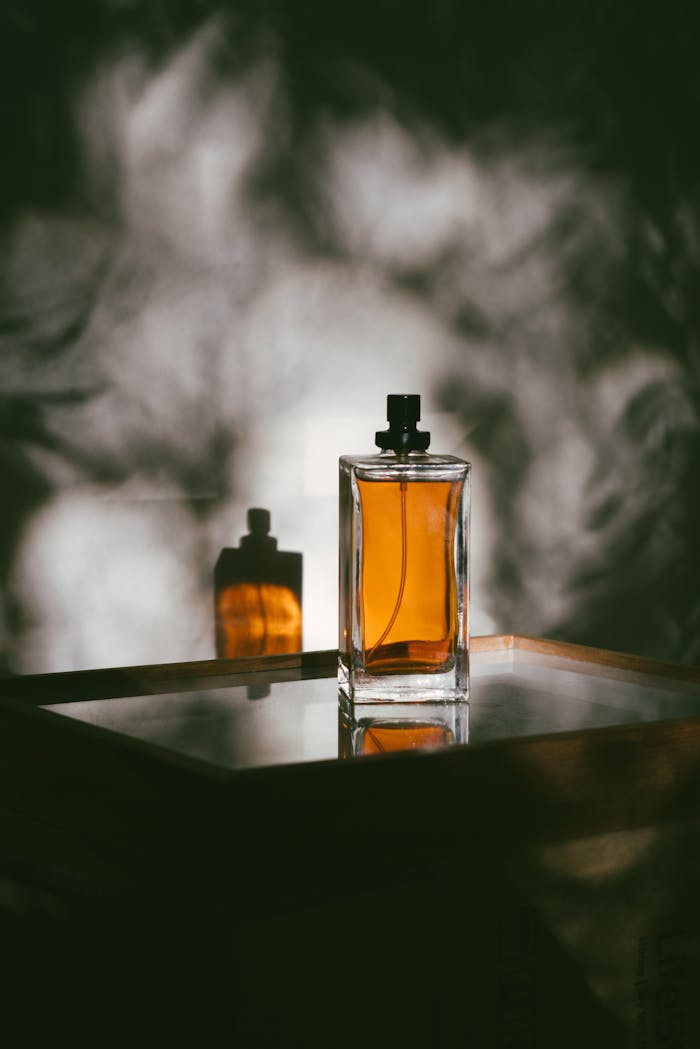 Services-02 A stylish perfume bottle casting shadows on a reflective surface, creating a moody ambiance.