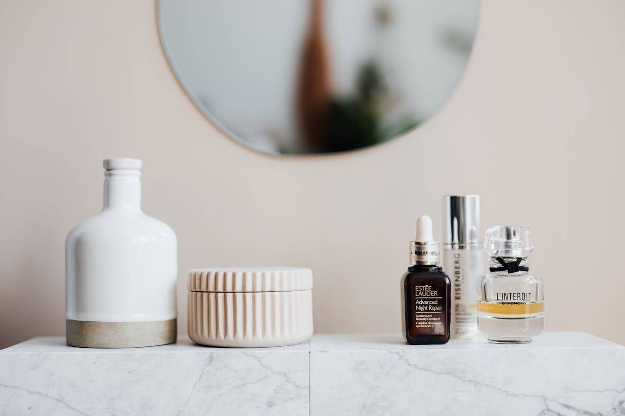 mobile-01 Stylized skincare and cosmetic bottles on a marble shelf with mirror reflection.